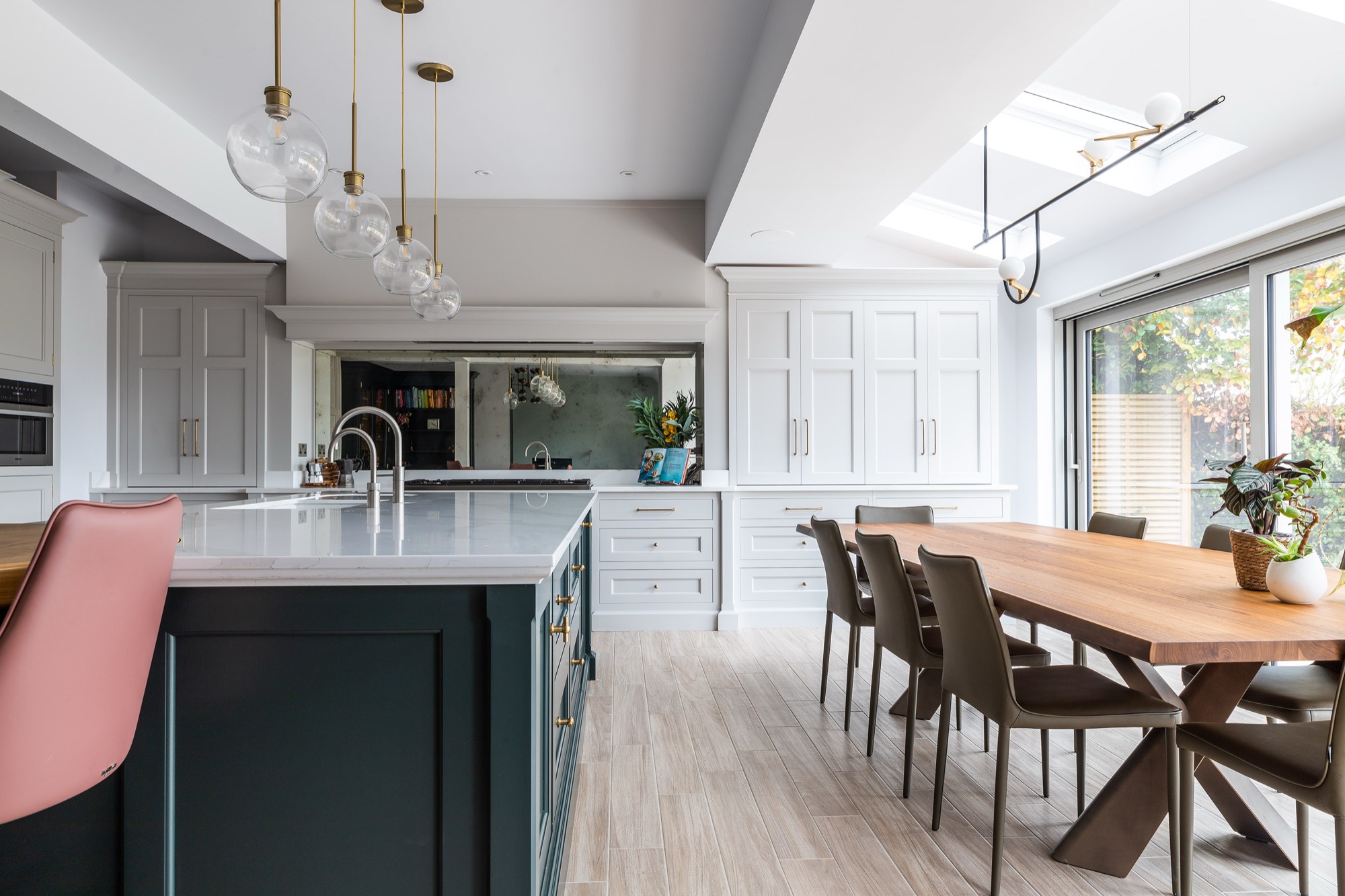 A completed open-plan kitchen and dining room with roof glazing and sliding doors to the garden